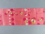 a pink ribbon with gold bells on it