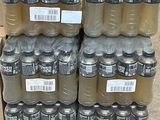 Des bouteilles d'eau sont empilées sur une palette dans un entrepôt