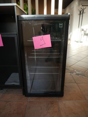 two refrigerators with sticky notes on them sitting on the floor