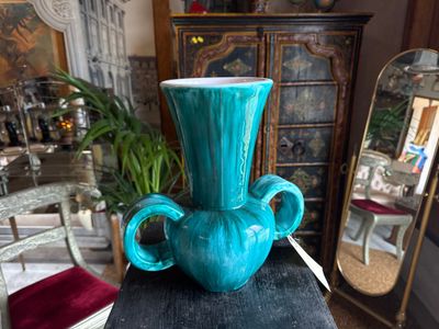 a blue vase sitting on top of a black table