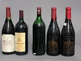 six bottles of wine are lined up in a row on a gray surface
