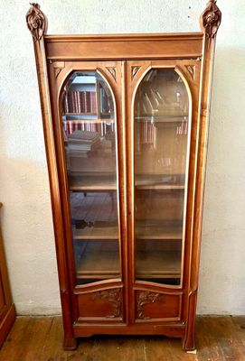 a wooden cabinet with a glass door in a room