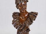un buste en bronze représentant une femme coiffée d'une coiffe