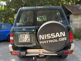 un 4x4 Nissan Patrol noir garé à côté d'une voiture bleue