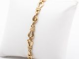 a close up of a gold chain bracelet on a pillow