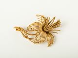 a close up of a bird brooch on a white surface