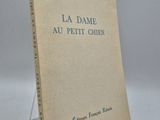 un vieux livre posé sur une table à côté d'un mur blanc