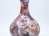 un vase avec un motif floral sur fond blanc