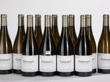 six bouteilles de vin sont alignées sur une surface blanche