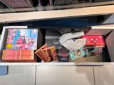 a drawer full of books and toys in a room