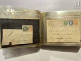 two old envelopes are sitting in a glass case on a table