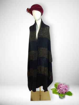 black and brown striped poncher with a red hat on a mannequin stand