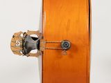 a violin that is sitting on a stand on a white surface
