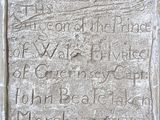 une vieille plaque en pierre portant une inscription, située devant un bâtiment
