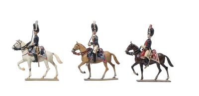 trois figurines représentant des hommes à cheval sur fond blanc