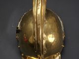 brass helmet on a black surface with a black background