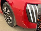 a close up of a red car with a measuring tape on it