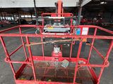 the red work platform is in the middle of a parking lot