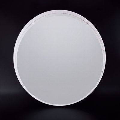 une photo représentant un miroir circulaire blanc sur fond noir