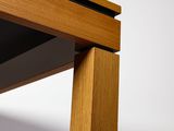 close up of a wooden table with a black top and a white background