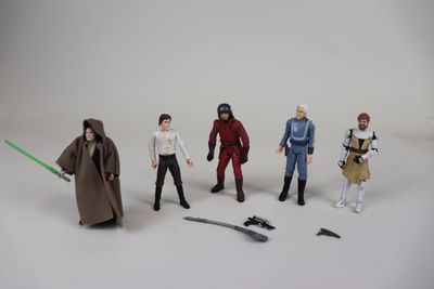 cinq figurines de personnages de Star Wars posées sur une surface blanche