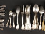 de nombreuses fourchettes et cuillères disposées sur la table