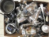 une boîte remplie de casseroles et de poêles en argent, posée par terre