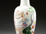 un vase blanc avec un tableau posé sur une table