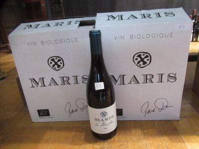 une bouteille de vin posée sur une table à côté d'une boîte