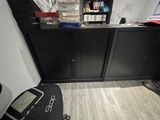 a desk with a computer and a chair in a room