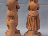 two clay figurines of people standing next to each other