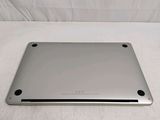 the back of a silver laptop sitting on top of a white surface