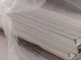a stack of books wrapped in plastic on a table