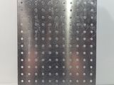 stainless steel plate with holes and rivets on a white surface