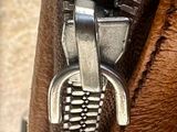 a close up of a zipper on a brown bag
