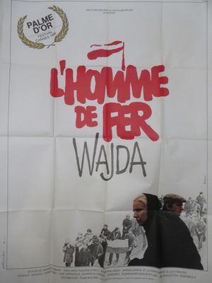 affiche de cinéma représentant un homme et une femme marchant devant une foule de gens