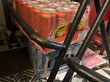 several cans of soda are stacked on a cart in a room