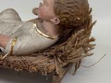 a figurine of a baby in a nest on a table