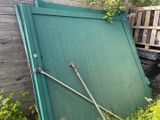 une porte verte appuyée contre une clôture en bois