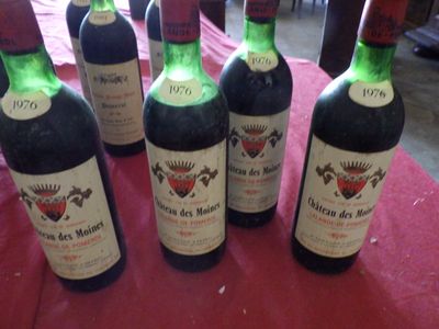 six bouteilles de vin sont alignées sur une nappe rouge