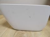a white bowl on a wooden table with a wall in the background