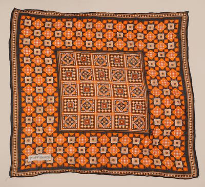 un tapis carré orange, noir et blanc, orné d'un motif