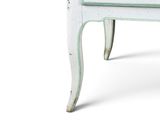a small white table with a drawer on top of it