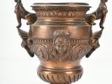 a bronze urn with two birds on it on a white background