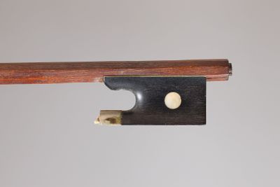 un gros plan d'un archet de violon sur lequel est fixé un morceau de bois