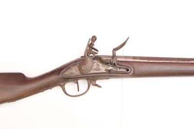 une vieille arme exposée sur un mur