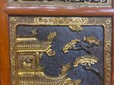 a wooden cabinet with a gold and black design on it
