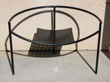une table en métal noir avec un porte-revues en dessous