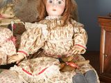 a doll that is sitting on a table next to a teddy bear