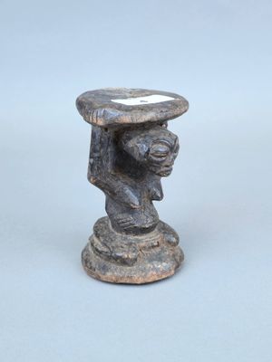 une image représentant une statue d'un homme tenant un bol sur la tête